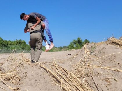 A Texas DPS trooper carries an injured Venezuelan migrant teen from the Rio Grande to a rescue station. (Texas Department of Public Safety)