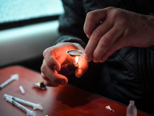A drug user prepares and injects heroine inside former drug user-turned-drug policy campai
