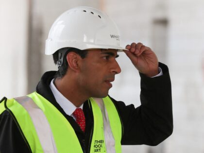 Britain's Chancellor of the Exchequer Rishi Sunak, wearing a hard hat and a hi-vis jacket, reacts as he visits a construction site during a local by-election campaign visit to the Northern School of Art in Hartlepool, north east England on, April 30, 2021. (Photo by LEE SMITH / POOL / …