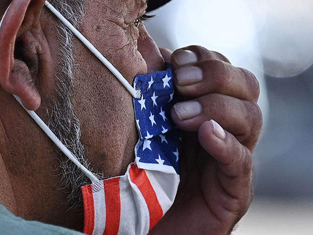 A man adjusts his American flag face mask on July 19, 2021 on a street in Hollywood, Calif