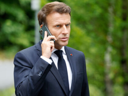 France's President Emmanuel Macron talks on his mobile phone as he arrives to give a press statement on June 28, 2022 at Elmau Castle, southern Germany, at the end of the G7 Summit. (Photo by Ludovic MARIN / AFP) (Photo by LUDOVIC MARIN/AFP via Getty Images)