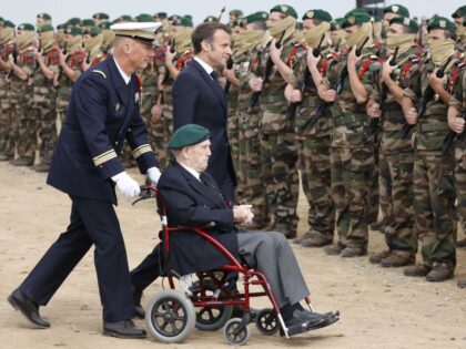 French President Emmanuel Macron (R) and French WWII veteran of the Commando Kieffer Leon Gautier (C) attend a ceremony in tribute to the 177 French members of the "Commando Kieffer" Fusiliers Marins commando unit who took part in the Normandy landings, as part of the 79th anniversary of the World …