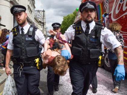 LONDON, UNITED KINGDOM - 2023/07/01: Police officers arrest a protester who was blocking the road during the demonstration. Just Stop Oil activists from the LGBTQ community sprayed pink paint and blocked the Pride In London Parade by sitting in front of a Coca-Cola truck taking part in the parade, in …