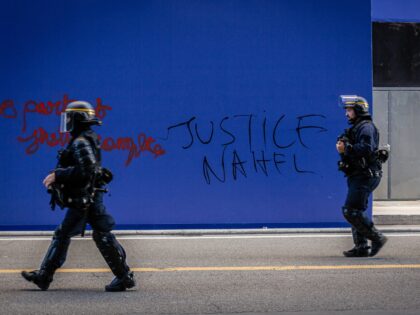 PARIS, FRANCE - 2023/06/30: Two police officers seen passing by a wall with "Justice for Nahel" written on it, during the spontaneous demonstration. On the fourth day of protests following the death of 17-year-old Nahel by police in Nanterre, on the outskirts of Paris, a spontaneous demonstration began in Place …