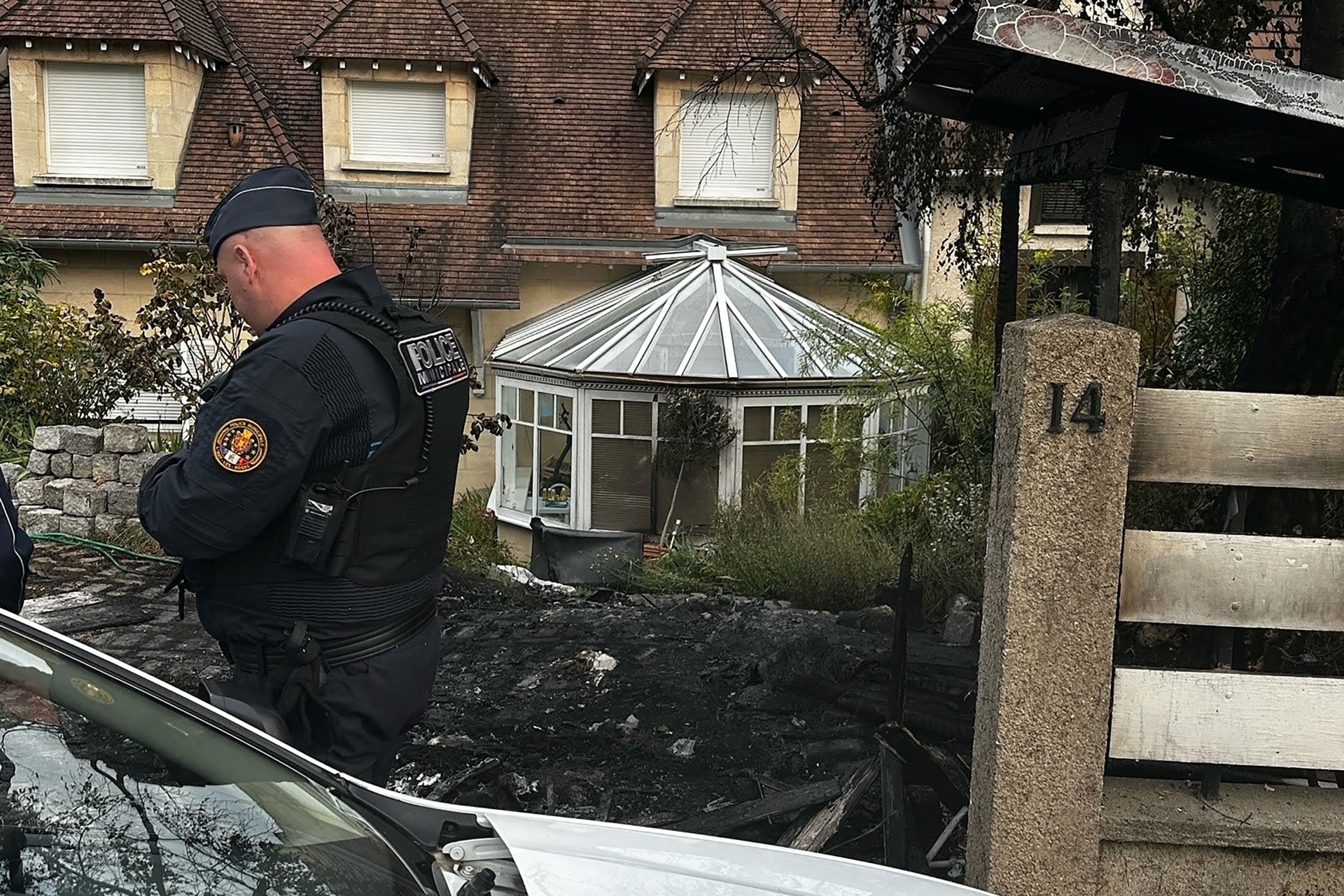 TOPSHOT - Municipal police officers stand in front of the damaged home of the Mayor of l'Hay-les-Roses Vincent Jeanbrun, in l'Hay-les-Roses, a suburb of Paris on July 2, 2023, after rioters rammed a vehicle into the building injuring the Mayor's wife and one of his children overnight, during continued disturbances across France after a 17-year-old man was killed by police in Nanterre, a western suburb of Paris on June 27. Rioters in France rammed a car into the home of the mayor of a town south of Paris, injuring his wife and one of his children, the mayor said July 2, 2023. (Photo by Nassim GOMRI / AFP) (Photo by NASSIM GOMRI/AFP via Getty Images)