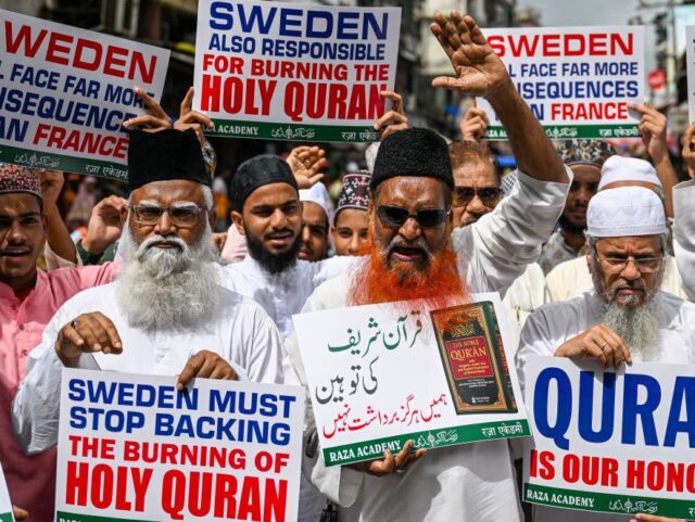 Muslim activists display placards as they shout anti-Sweden slogans during a protest again