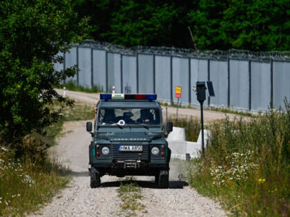 JUROWLANY, POLAND - JULY 09: Polish border guard patrols by the metal wall between the Pol