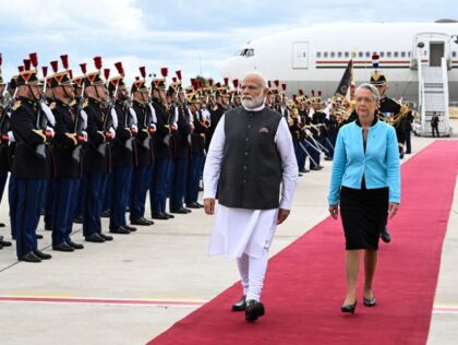 India's Prime Minister Narendra Modi (2R) and France's Prime Minister Elisabeth Borne (R) walk past French Republican Guards at the Orly airport in Orly, Paris' suburb, on July 13, 2023. Indian Prime Minister Narendra Modi begins a two-day visit to France on July 13, 2023 where he will attend the …
