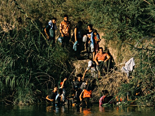 Migrants walk along the Rio Grande River in Eagle Pass, Texas, US, on Thursday, July 13, 2