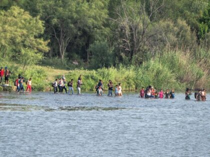 Migrants cross the Rio Grande from the Mexican side towards the US on July 16, 2023 in Eagle Pass, Texas. The buoy installation is part of an operation Texas is pursuing to secure its borders, but activists and some legislators say Governor Greg Abbott is exceeding his authority. (Photo by …