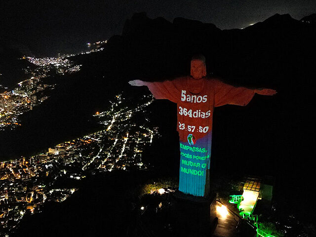 Aerial view showing the Climate Clock -- which indicates the alleged time left to act to limit global warming to 1.5 degrees Celsius -- is projected onto the Christ the Redeemer statue, in Rio de Janeiro, Brazil, on July 22, 2023. (Photo by Carlos FABAL / AFP) (Photo by CARLOS …