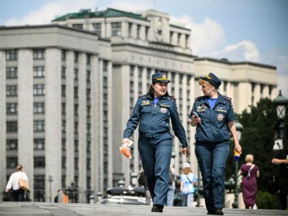 Russian Emergency Ministry (MChS) personnel walk in front of the Russian State Duma (lower