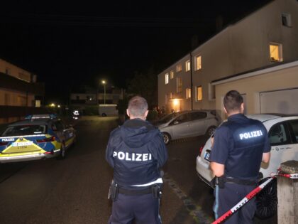 29 July 2023, Bavaria, Langweid: Police officers stand in front of a house where three peo