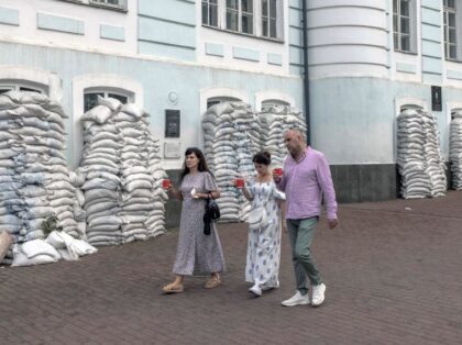 People walk past sandbags protecting the windows of a building in Kyiv's Podil neighborhood, on July 30, 2023, amid the Russian invasion of Ukraine. (Photo by Roman PILIPEY / AFP) (Photo by ROMAN PILIPEY/AFP via Getty Images)