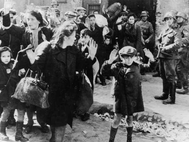 A group of Jewish civilians being held at gunpoint by German SS troops after being forced