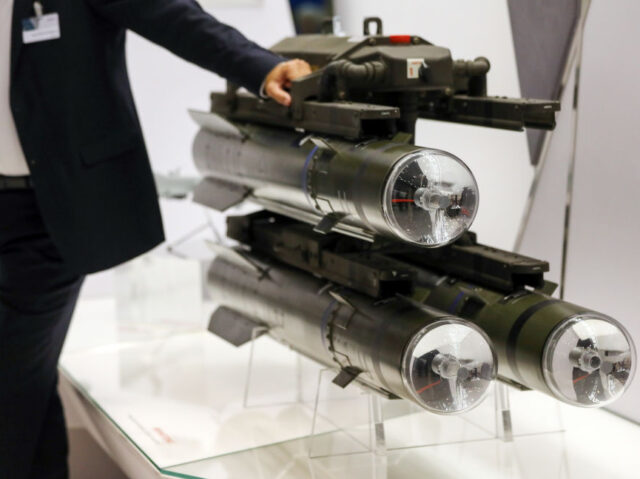 An attendee leans on a Brimstone missile, manufactured by MBDA Inc., during the Defense an