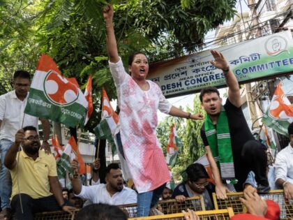 A member of the Assam Pradesh Youth Congress is shouting slogans with red ink on her cloth
