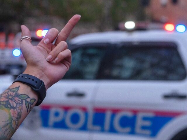 A protester holds up the middle finger and gestures toward Columbus Police during an &quot
