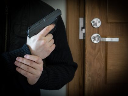 Self-DefenseArmed man with gun waiting his victim near the door. - stock photo