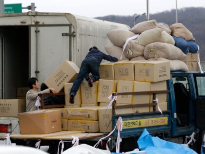 A South Korean man, center, unloads boxes transported from North Korea's Kaesong as r