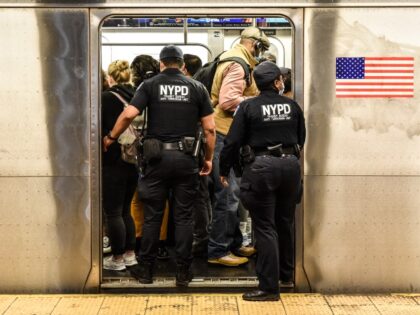 New York Police Department (NYPD) officers enter a subway at a station in New York, US, on