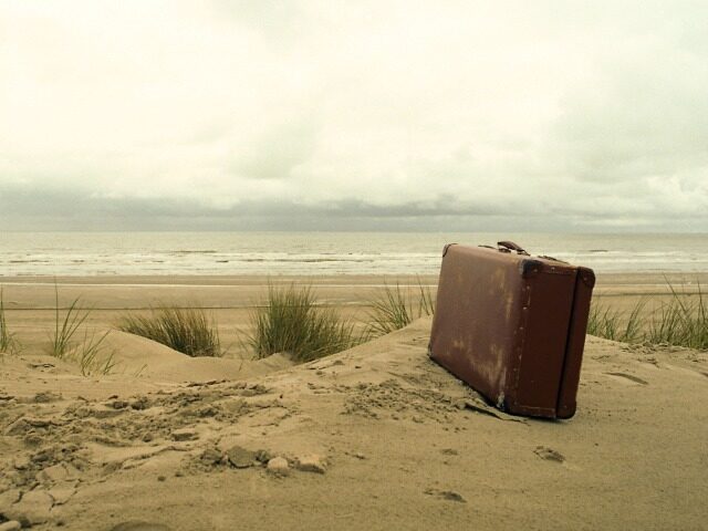 vintage suitcase on the sand dunes in Bray-Dunes, France.