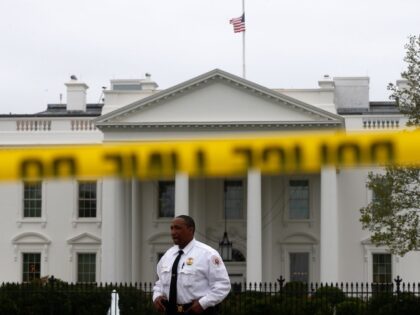 A Uniformed Division Secret Service officer stands guard behind police tape on Pennsylvania Avenue, which is closed to pedestrians, in front of the White House in Washington, Tuesday, April 16, 2013, with the American flag is seen at half staff above the White House, following the explosions at the Boston …