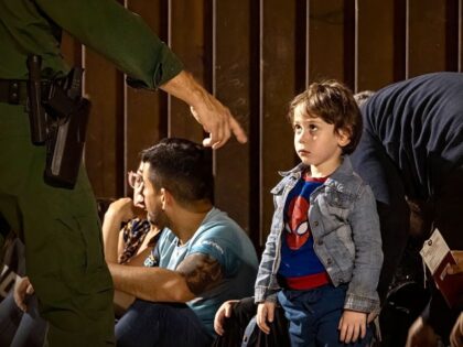 YUMA, ARIZONA - JUNE 21: An immigrant child wearing a Spiderman T-shirt looks at a U.S. Bo