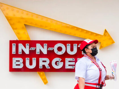 SANTA ANA, CA - APRIL 01: A In-N-Out Burger employee walks past the signage and the new In
