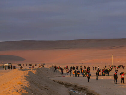 Migrants walk through the desert in the direction of Peru after clashes with the Chilean a