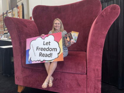 School librarian Jamie Gregory, from South Carolina, displays two books that have been repeatedly challenged in the United States, while seated at the Banned Books from the Big Chair station at the American Library Association's annual conference in Chicago, June 24, 2023. The two books are: "Gender Queer," by Maia …