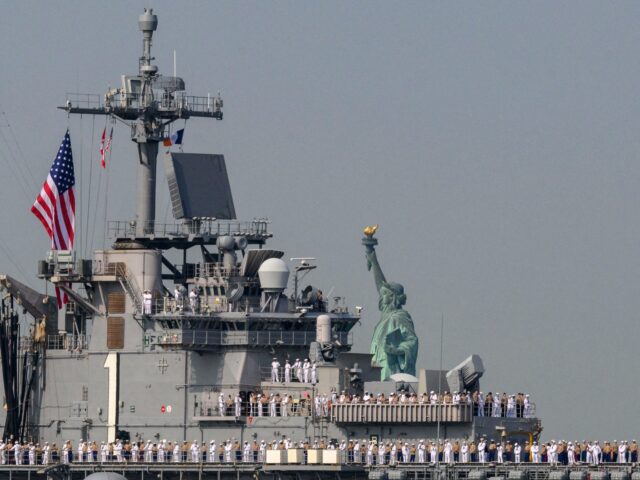 US Sailors and Marines stand on the flight deck of the USS Bataan, a Wasp-class amphibious assault ship, as it passes the Statue of Liberty during Fleet Week in New York Harbor on May 24, 2023. (Photo by ANGELA WEISS / AFP) (Photo by ANGELA WEISS/AFP via Getty Images)