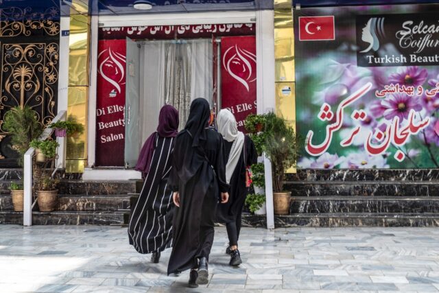 Afghan women walk into a beauty salon in Kabul on the last day they were allowed to be ope