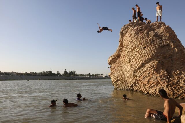 An Iraqi dives into the waters of the Tigris river in Baghdad on July 12, 2023, as tempera