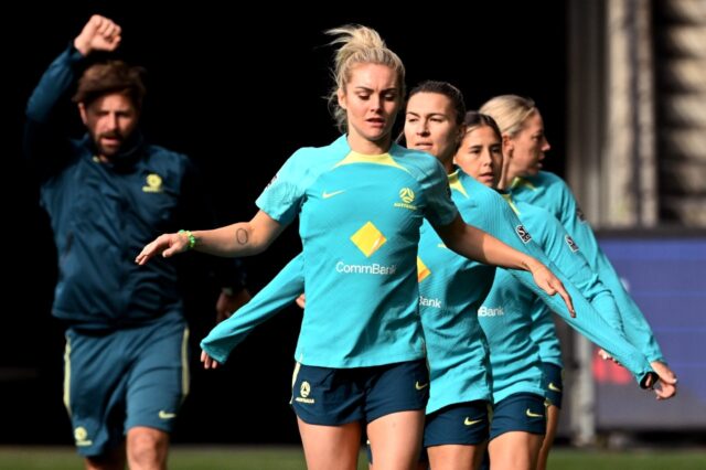 Australia's Ellie Carpenter (C) and her teammates go through their stretching exercises du