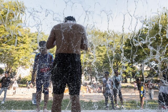 A man cools off at a park's water playground in eastern Tokyo, as temperatures in the mid-