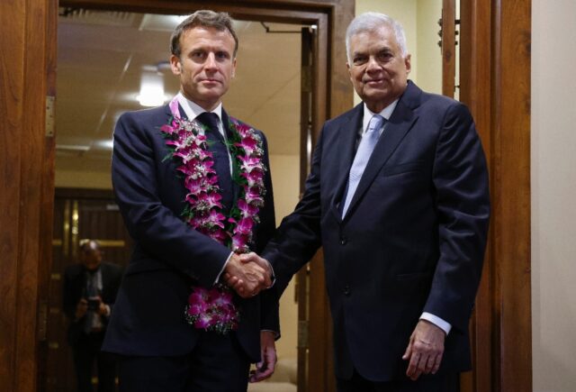 France's President Emmanuel Macron (L) shakes hands with Sri Lanka's President Ranil Wickr