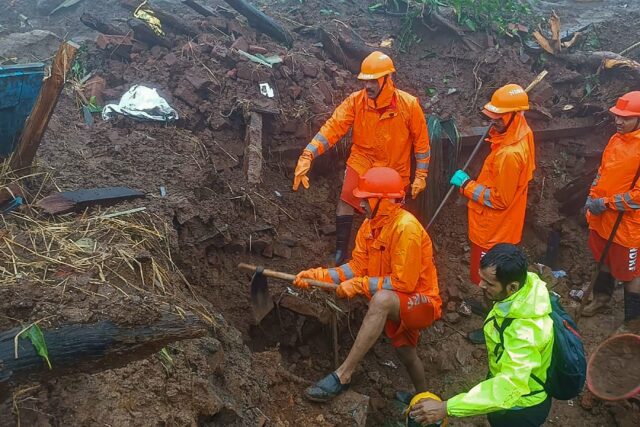 India's National Disaster Response Forcepersonnel inspect the site of a landslide at Irsha