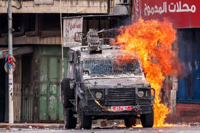 A Molotov cocktail explodes on an Israeli armoured vehicle during an army raid in Nablus