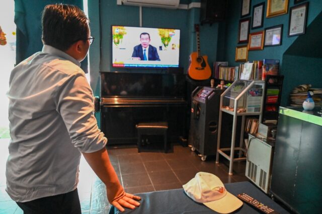 A man in Phnom Penh watches as Cambodia's Prime Minister Hun Sen speaks during a televised