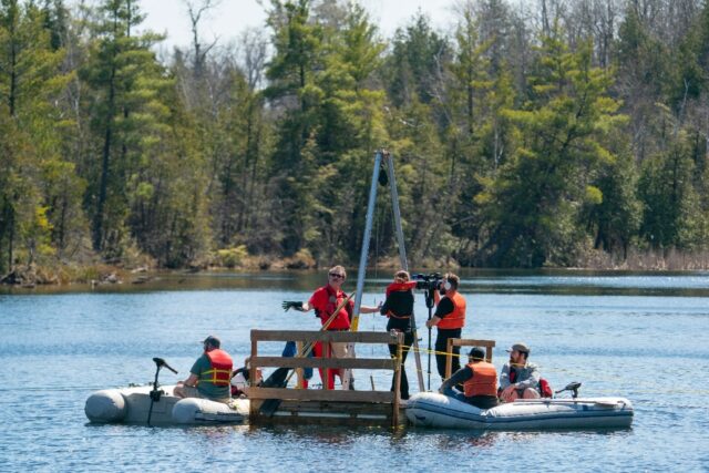 Professor Patterson collects sediment samples from the bottom of Crawford Lake near Milton