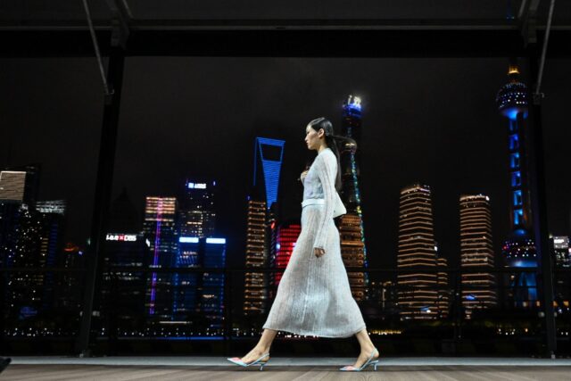 Against Shanghai's glittering river skyline, Kenzo-clad models strutted down a breezy open