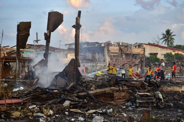 Thai firefighters put out embers around destroyed homes after an explosion ripped through