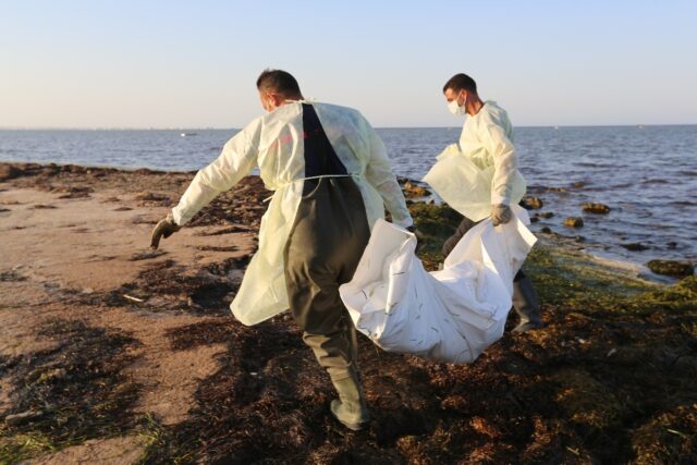 Tunisian civil protection workers recover the body of an African migrant near the eastern
