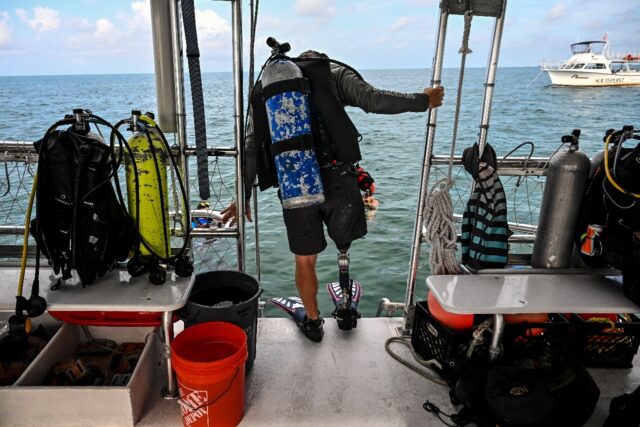 Veteran Billy Costello readies to jump in the water to plant coral in a reef near Key West
