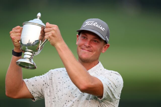 Vincent Norrman of Sweden celebrates with the trophy after winning a playoff to capture th