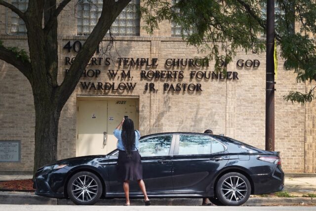 A woman takes a picture of the Roberts Temple Church of God in Christ in Chicago, which wi