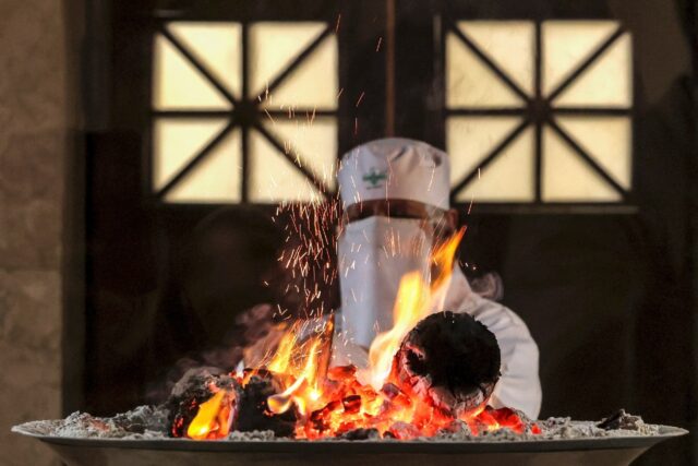 A Zoroastrian priest adds wood to the Atash Bahram ("Fire of Victory" or Eternal Flame) in