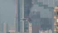 Fire on New York construction crane causes arm to collapse and hit a building as it falls