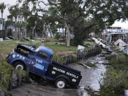 Pick up trucks and debris lie strewn in a canal in Horseshoe Beach, Fla., after the passage of Hurricane Idalia, Wednesday, Aug. 30, 2023. (AP Photo/Rebecca Blackwell)